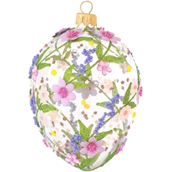 Artfully hand-crafted in Poland, this gorgeous clear glass egg is embellished with fabric, beads, and glitter in a pink and purple flower motif. Elegant and colorful, this glass egg ornament with pink and purple flowers will make a stunning keepsake for
