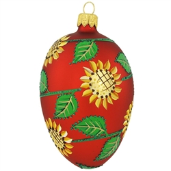 Bringing to mind the bountiful blooms of summer, this resplendent glass egg is decorated with a garden of vivid yellow sunflowers and verdant green leaves. Shimmering with a beautiful red matte surface, this egg-quisite ornament measures 3½" tall and is m