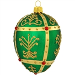 Shimmering in a bright hue of emerald green, this stunning glass ornament was inspired by the famous jeweled eggs of the House of Faberge, in St. Petersburg, Russia. Featuring dazzling gold glitter folk patterns surrounded by metallic gold lines studded