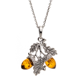 Sterling silver oak leaves hold two honey amber acorns. Pendant size is approx. 1" h x .75" w.