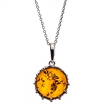 A sterling silver crown is the frame for this beautiful round honey amber cabochon.  Pendant size is approx. 1" x .75".