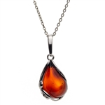 A beautiful cherry amber cabochon framed in an open back sterling silver frame. Pendant size is approx. 1" x .5".