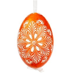 This beautifully designed egg is dyed one color, then white wax is melted and applied to form an intricate design which is left on the surfce. The egg is emptied and strung with ribbon for hanging.