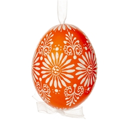 This beautifully designed egg is dyed one color, then white wax is melted and applied to form an intricate design which is left on the surfce. The egg is emptied and strung with ribbon for hanging.