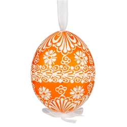 This beautifully designed egg is dyed one color, then white wax is melted and applied to form an intricate design which is left on the surfce. The egg is emptied and strung with ribbon for hanging.