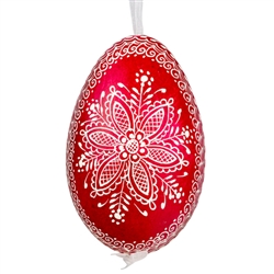 This beautifully designed egg is dyed one color, then white wax is melted and applied to form an intricate design which is left on the surfce. The egg is emptied and strung with ribbon for hanging.