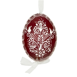 This beautifully designed egg is dyed one color, then white wax is melted and applied to form an intricate design which is left on the surfce. The egg is emptied and strung with ribbon for hanging.