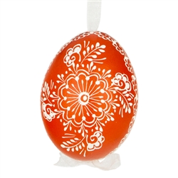 This beautifully designed egg is dyed one color, then white wax is melted and applied to form an intricate design which is left on the surfce. The egg is emptied and strung with ribbon for hanging.