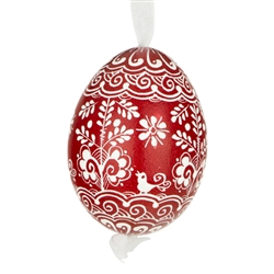 This beautifully designed egg is dyed one color, then white wax is melted and applied to form an intricate design which is left on the surfce. The egg is emptied and strung with ribbon for hanging.