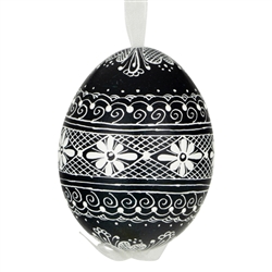 This beautifully designed egg is dyed one color, then white wax is melted and applied to form an intricate design which is left on the surfce. The egg is emptied and strung with ribbon for hanging.