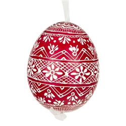 This beautifully designed egg is dyed one color, then white wax is melted and applied to form an intricate design which is left on the surfce. The egg is emptied and strung with ribbon for hanging.