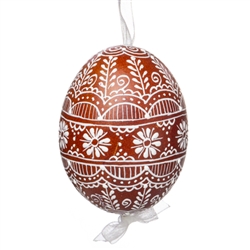 This beautifully designed egg is dyed one color, then white wax is melted and applied to form an intricate design which is left on the surfce. The egg is emptied and strung with ribbon for hanging.