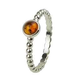 An oval of honey amber set in an artistic swirl of sterling silver.