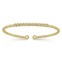 12 round diamonds align in this 14k yellow gold diamond cuff bracelet.