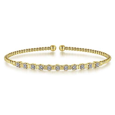 11 Round brilliant diamonds glisten in this 14k yellow gold beaded bangle bracelet.