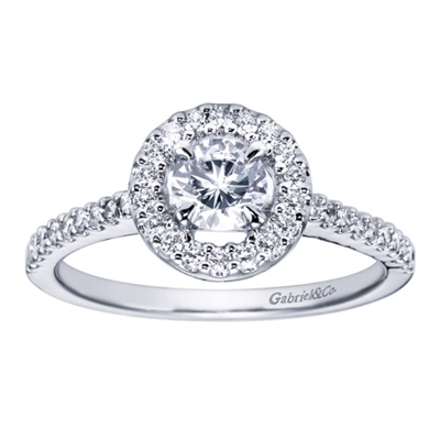 A round brilliant diamond halo sets up a bold round center diamond, accompanied by round brilliant diamonds all along the band of this white gold or platinum contemporary halo engagement ring.