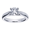 A sturdy, 4 prong setting in white gold or platinum shows off a round center diamond in this contemporary solitaire engagement ring.