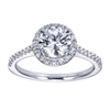 Round brilliant diamonds grace this contemporary halo engagement ring with shine, and the round halo at its center cushions and lifts a round center diamond of your choice.