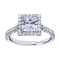 A princess cut center diamond is wrapped with round brilliant diamonds in this contemporary style princess engagement ring available in white gold or platinum.