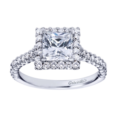 A princess cut center diamond is wrapped with round brilliant diamonds in this contemporary style princess engagement ring available in white gold or platinum.