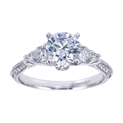 A 3 stone diamond engagement ring with intricate metal work and a flair for the dramatic.