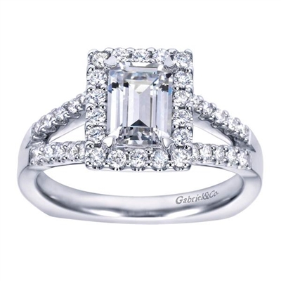 This split shank halo engagement ring perfectly houses an emerald cut center diamond with nearly one half carats of round brilliant diamonds.