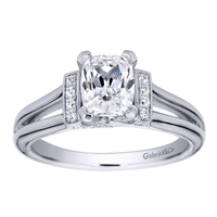 This split shank diamond engagement ring is in a solitaire style with the round diamonds assembling at the center, surrounding the oval cut diamond of your choice.