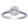 A sleek white gold band leads up to a round diamond halo engagement ring with a round center diamond already included!