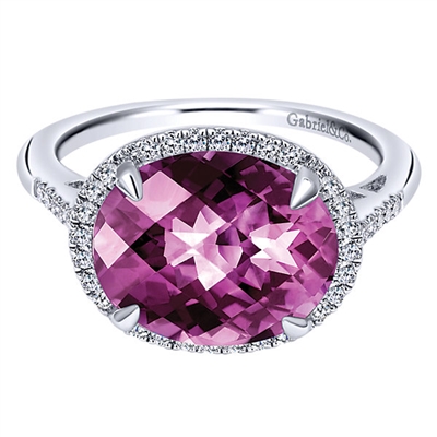 Nearly one quarter carats of round brilliant diamonds in a halo surround a center purple amethyst in this classic and unique 14k white gold gemstone ring.