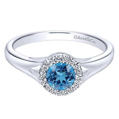 This stunning and simple blue topaz and diamond ring features diamond accents that surround a swiss blue topaz in this 14k white gold ring.