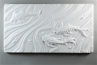 A long rectangular tile made of white ceramic. The carved texture on it shows a top-down view of three koi fish, two at the bottom right and one in the top left. The remainder of the space is filled with waving watery lines and a few round bubbles.