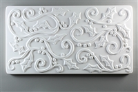 A long rectangular tile made of white ceramic. The carved texture is filled with curving lines with holly leaves and small round holly berries attached at various points.