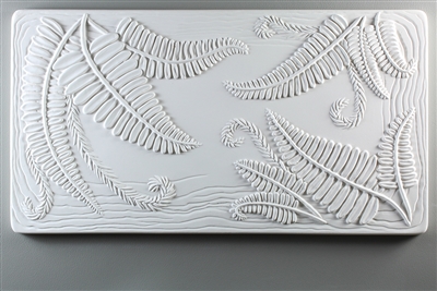 A long rectangular tile made of white ceramic. The carved texture shows several bunches of long ferns extending from the top left, top right, and bottom right corners. There are a few slightly waved lines around the tile border behind the ferns.