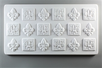 A long rectangular tile made of white ceramic. The carved texture has eighteen fleur-de-lis emblems arranged in three rows of six. Every other emblem has a square background around it.