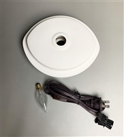 A top-down view of a white ceramic lamp base on a grey background. The base is a pointed oval with a raised lip around the edge and hole in the center. There is an oval lightbulb and tied electrical cord below it.