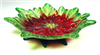 A footed glass dish. The dish itself is made from a frit cast poinsettia flower with yellow center and petals with bright red bases and light green tips. The feet of the dish are formed from dark green frit cast leaves.