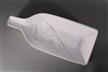 A bottle-shaped white ceramic mold for fusing glass on a grey background. The outer edges curve upwards, giving the mold a bowl-like shape. The mold has been carved with three dragonflies surrounded by swirling lines. The middle dragonfly is the largest.