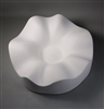 A circular white ceramic mold for fusing glass on a grey background. It is carved into a gently waving shape around its outside, which slopes gradually downwards into a small flat circle in the very middle.