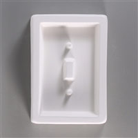 A rectangular, white ceramic mold for fusing hot glass on a grey background. A smaller rectangle has been carved into it.  There is a raised smaller rectangle in the center, and one protruding post above that center and one post below.