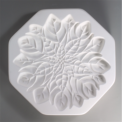 An octagonal, white ceramic mold for fusing hot glass on a grey background. A large and intricately detailed flat poinsettia flower has been carved into it.