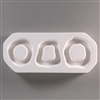 A rectangular, white ceramic mold for fusing hot glass on a grey background. Three wavy ring shapes have been carved into it. The leftmost ring is circular, the middle is more trapezoidal, and the rightmost is a larger, wavier circle.