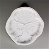 A circular, white ceramic mold for fusing hot glass on a grey background. A realistic flat pansy flower has been carved into it. The flower takes up most of the mold, but there is a small border of empty space around it.