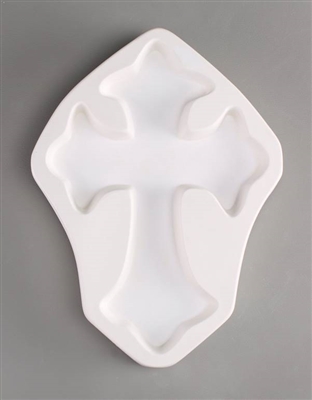 A cross-shaped white ceramic mold for fusing hot glass on a grey background. A simple cross has been carved into it.