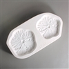 A rectangular white ceramic mold for fusing hot glass on a grey background. Two flat detailed hibiscus flowers have been carved into it. The left flower is slightly larger but both flowers have similar designs.