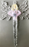 A fused glass fairy ornament hanging in front of a gray background. The fairy has light blonde hair and an opaque pink gown and is holding a silver snowflake. They have transparent snowflake wings and their body tapers into a clear icicle.