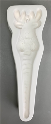 A long white ceramic mold for fusing hot glass on a grey background. A reindeer in a knit scarf with hooves facing forward and a body tapering into an icicle has been carved into it. The antlers have a post between them allowing for hanging after firing.