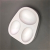 A roughly oval white ceramic mold for fusing hot glass on a grey background. Three separate large eggs in two different sizes have been carved into it. The top egg is larger while the two eggs below it are smaller.