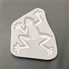 A white ceramic mold for fusing hot glass on a grey background. A top-down view of a large frog has been carved into it. The frog is plain in design and facing slightly to the left. Its arms and legs are bent as if mid-jump.