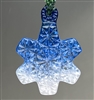 A fused glass snowflake ornament hanging in front of a grey background. The ornament has an intricate cut crystal design all over it and is filled with a color gradient going from dark blue at the top to white at the bottom.