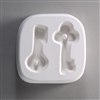 A square white ceramic mold for fusing hot glass on a grey background. Two different key shapes have been carved into it. The left key has a circular top and the right has a clover-shaped top. Both tops have posts to string the final glass pieces through.